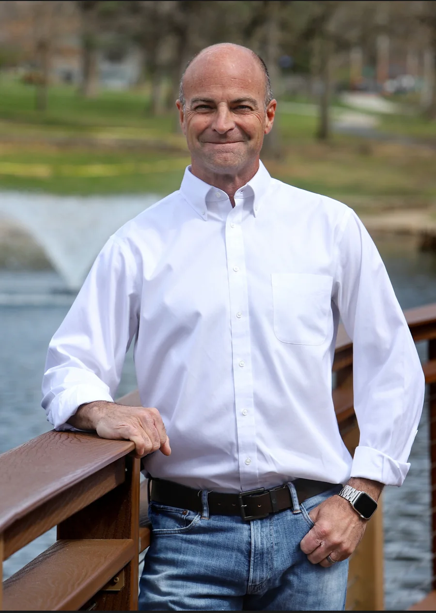 Chip VanHouden standing beside a wooden railing outdoors
